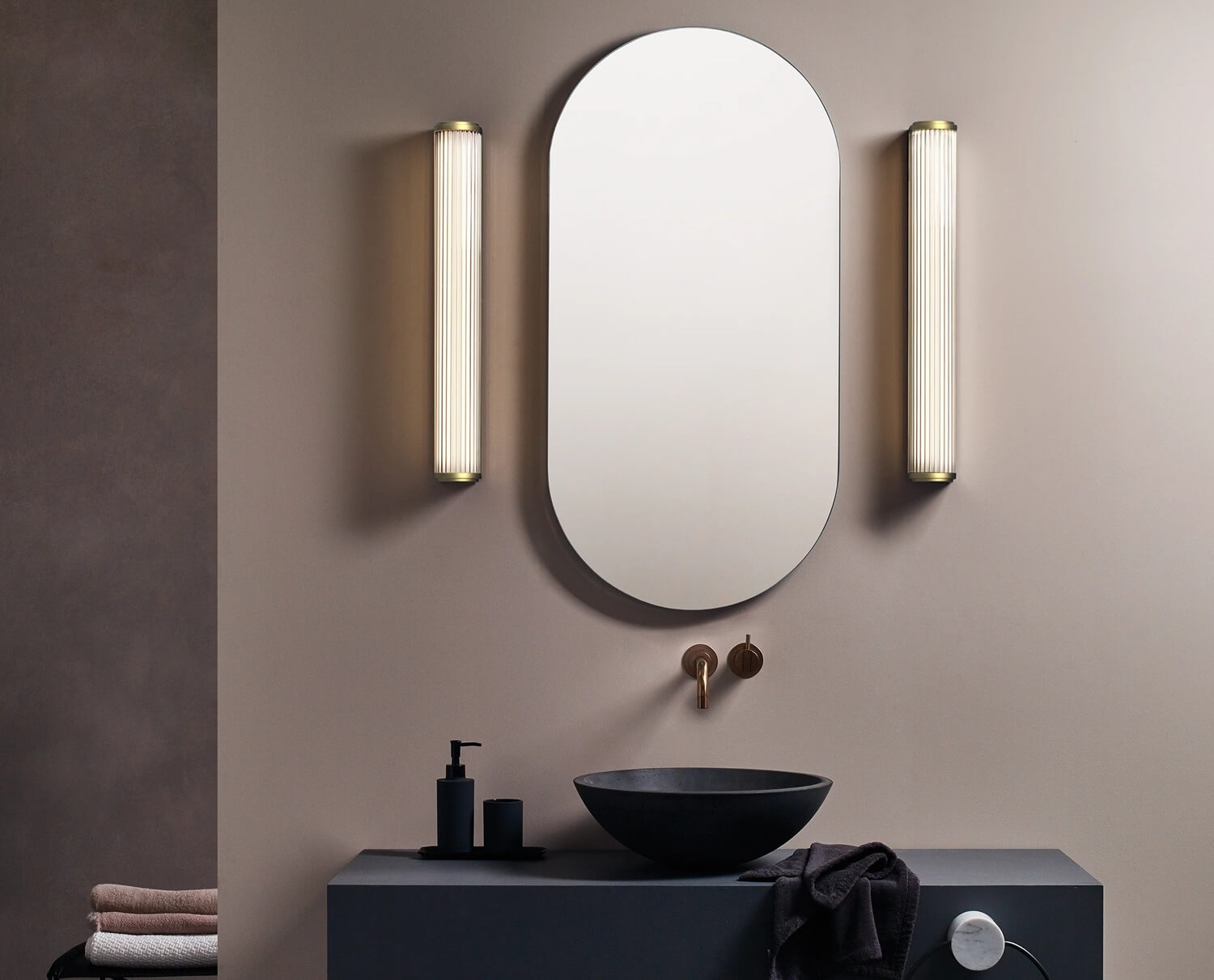 Gold wall sconces on both sides of the bathroom mirror.
